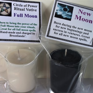 May include: Two votive candles, one white and one black, in clear plastic packaging. Each candle has a label with text. The white candle's label reads "Circle of Power Ritual Votive Full Moon". The black candle's label reads "New Moon".