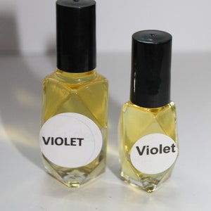 May include: Two clear glass bottles with black caps and white labels. The labels say "Violet".