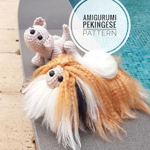 May include: Two crocheted Pekingese dogs, one brown and white, the other beige, sitting on a stone surface near a pool. The larger dog is lying down with its head raised and the smaller dog is sitting up. The image includes the text "Amigurumi Pekingese Pattern".