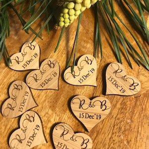 Könnte beinhalten: Holz-Herz-Hochzeitsgeschenke mit den Initialen "R & B" und dem Datum "15 Dec'19" auf jeder.