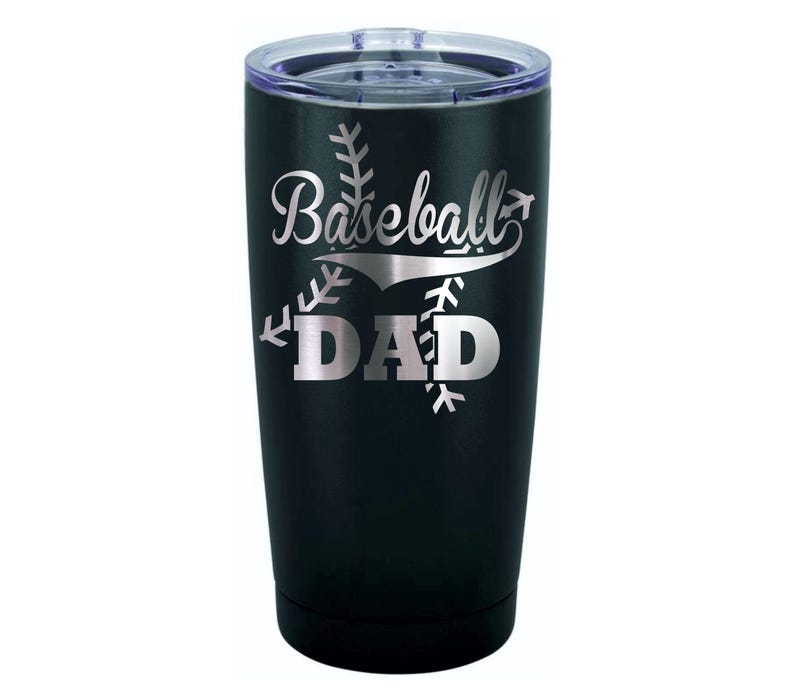 May include: Black stainless steel tumbler with a silver inscription that reads "Baseball Dad" with a baseball graphic.