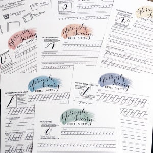 May include: A collection of calligraphy drill sheets with the words "Gloriously Sweary" in elegant script. Each sheet features practice strokes, diagrams, and the text "Drill Sheets". The sheets are arranged on a white surface.