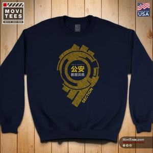 May include: Navy blue sweatshirt with a gold graphic design. The design includes Japanese text and the words "PUBLIC SECURITY" and "SECTION". The sweatshirt has a crew neck and long sleeves. The brand logo is in the upper left corner, and "MADE IN THE USA" is in the upper right corner.