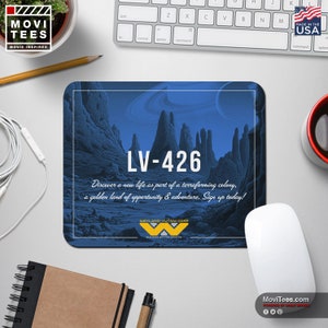 以下が含まれることがあります： 青と白の風景デザインの長方形マウスパッド。テキスト「LV-426」と「テラフォーミングコロニーの一員として新しい生活を発見してください」というフレーズが特徴です。マウスパッドには、Weyland-Yutani Corpのロゴも含まれています。