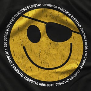 May include: Black t-shirt featuring a distressed yellow smiley face with an eye patch. White binary code circles the smiley face. The design has a vintage, worn look.