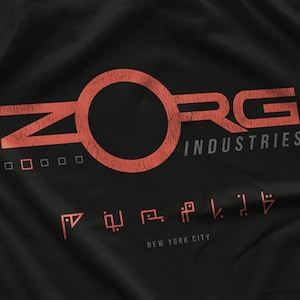 May include: A black t-shirt with a red and white logo that says "ZORG INDUSTRIES" and "NEW YORK CITY".