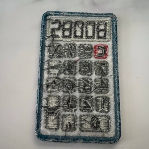 May include: A blue and white embroidered patch of a calculator with the number "28008" displayed on the screen.