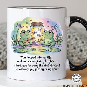 May include: White ceramic mug with a black handle and rim, featuring a colorful illustration of two cartoon frogs. One frog plays a ukulele, and the other dances. Text reads, "You hopped into my life and made everything brighter."
