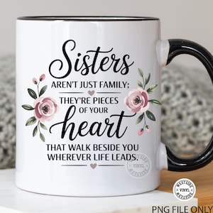 Op de afbeelding: Witte keramische mok met een zwarte handgreep en rand. De mok heeft de tekst "Sisters aren't just family; they're pieces of your heart that walk beside you wherever life leads." Versierd met roze en groene bloemmotieven.
