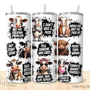 May include: Three white cylindrical tumblers featuring various illustrations of cows with black paint splatter accents and text including phrases like Not My Fucking Problem, I Don't Give A Fuck, Would You Shut The Fuck Up, and Not Today Satan.