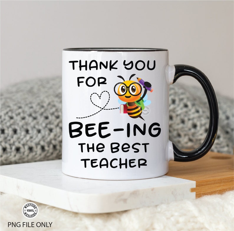 May include: White ceramic coffee mug with a black rim and handle. The mug features a cartoon bee wearing glasses and holding a pencil and book. The text on the mug reads "Thank you for bee-ing the best teacher".