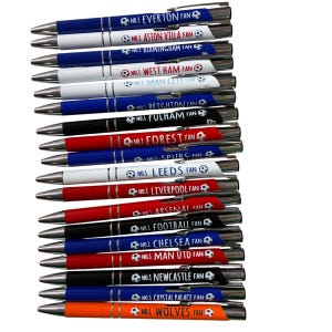 Könnte beinhalten: Eine Sammlung von Kugelschreibern mit silbernen Akzenten. Jeder Stift trägt den Namen eines Fußballteams und den Text "NO.1 FAN" zusammen mit einer Fußballgrafik. Die Stifte sind in verschiedenen Farben erhältlich, darunter Blau, Rot, Weiß und Orange.