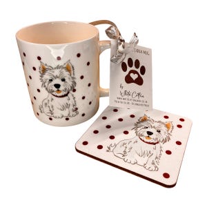 May include: A white ceramic mug and coaster set with a West Highland White Terrier design. The mug and coaster have a white background with maroon polka dots. The mug has a beige interior and a brown handle. The coaster is square.