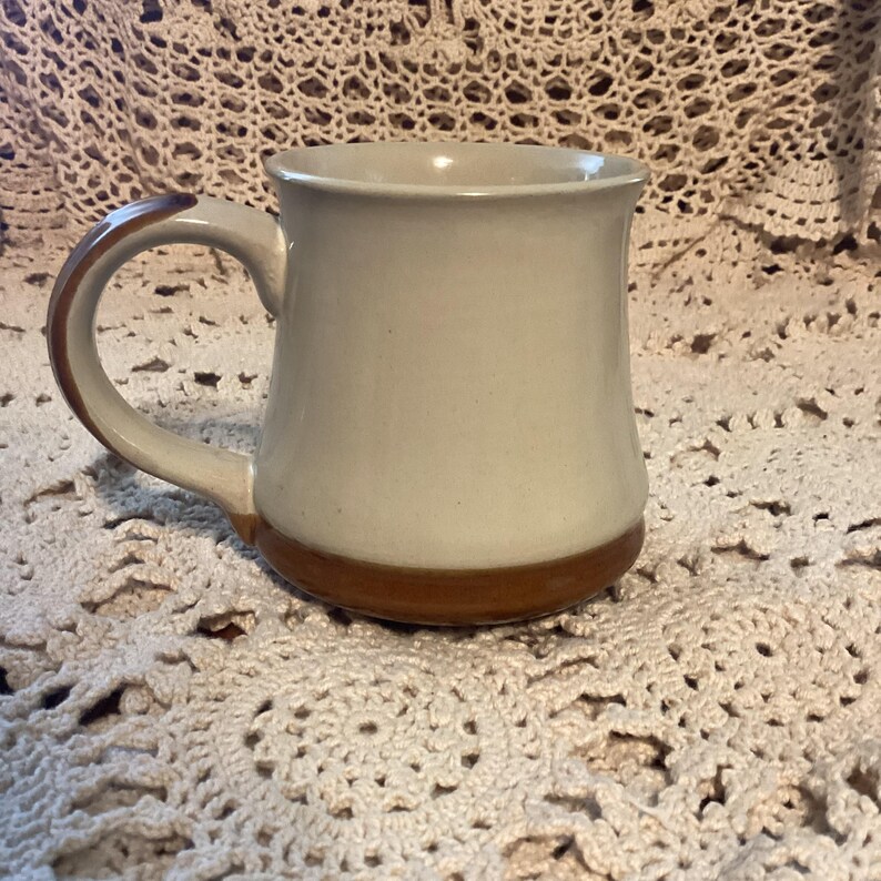 Pu&ograve; includere: Una tazza in ceramica con corpo color crema e base e manico marroni. La tazza ha un design semplice e classico, adatta per caff&egrave; o t&egrave;. Il manico &egrave; curvo e facile da impugnare.