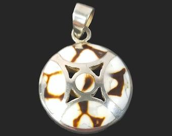 May include: A silver pendant with a round, white and brown shell inlay. The shell has a geometric pattern and is set in a silver frame.