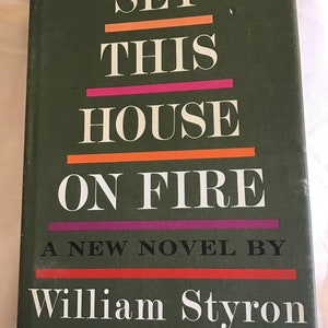 May include: A green book cover with the title "Set This House On Fire" in white letters with colorful lines. The author's name, "William Styron", is printed below the title in white letters. The book is by the author of "Lie Down In Darkness".