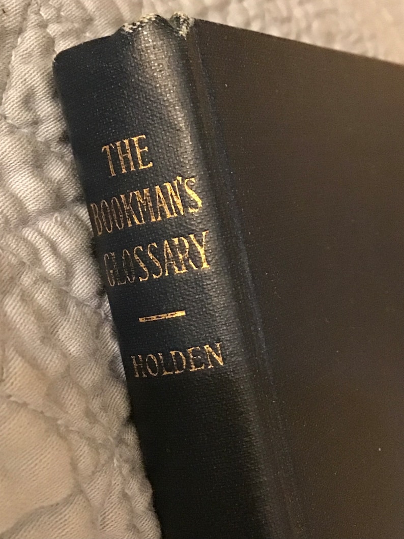 May include: A black book with gold lettering on the spine. The title is "The Bookman's Glossary" by Holden.