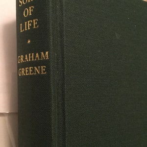 May include: A green hardcover book with the title "A Sort of Life" by Graham Greene printed in gold lettering.