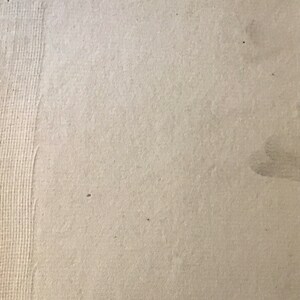 Op de afbeelding: Een close-up van een beige papieroppervlak met het nummer "60/30" geschreven in zwarte inkt.
