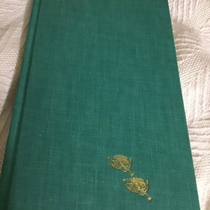 Pu&ograve; includere: Un libro rilegato in verde con accenti in foglia d'oro sulla copertina.