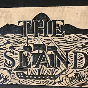 Op de afbeelding: Een zwart-witte illustratie van een schip dat op zee vaart met de tekst "THE ISLAND" erboven.