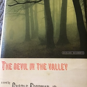 May include: Book cover with a foggy forest scene in the background. The title "The Devil in the Valley" is in red text. The author is Castle Freeman, Jr. and the book is published by Overlook Duckworth.