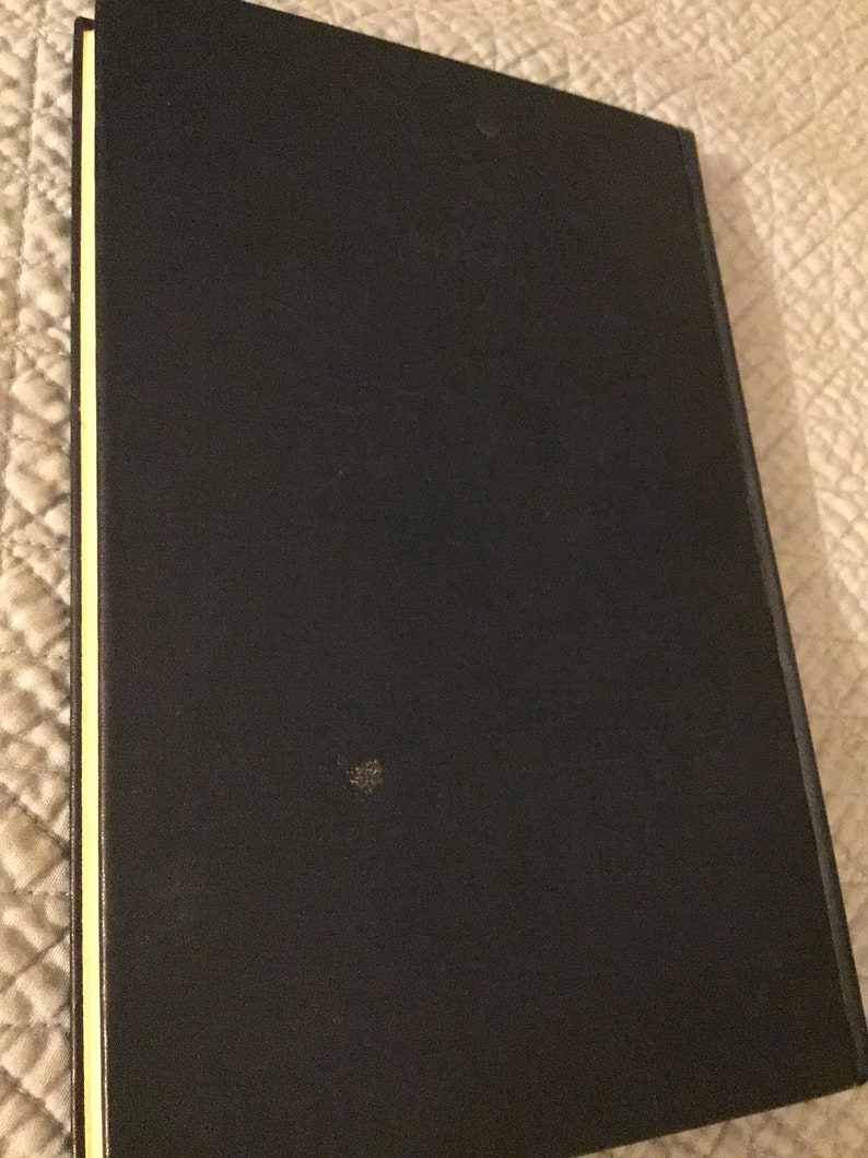 May include: A black hardback book with a gold spine.