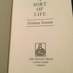 May include: A book cover with the title "A Sort of Life" by Graham Greene. The cover features a black and white illustration of a man in a suit and a white collar.