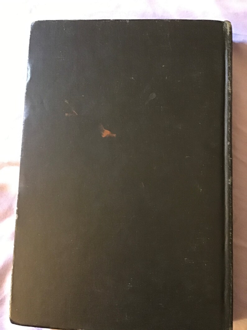 Op de afbeelding: Een donkergroen hardback boek met een versleten, getextureerde kaft.