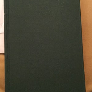 May include: A dark green hardcover book with a smooth, textured cover.