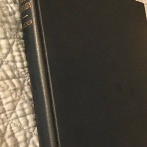 May include: A black leather-bound book with gold lettering on the spine that reads "The Merriam-Webster's Dictionary".