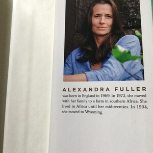 Puede incluir: P&aacute;gina de libro con un retrato de Alexandra Fuller. La imagen muestra a una mujer con cabello casta&ntilde;o largo que lleva una camisa azul. El texto debajo de la foto proporciona detalles biogr&aacute;ficos, incluido su nacimiento en Inglaterra y su traslado a Wyoming. El logotipo de Penguin Press est&aacute; en la parte inferior.