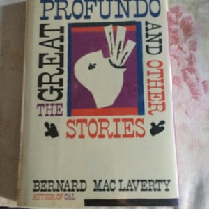 May include: A paperback book titled "Profundo and Other Stories" by Bernard Mac Laverty. The cover features a white illustration on a purple background, with the title in blue and red text. The author's name is printed in black.