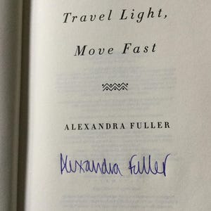 Puede incluir: P&aacute;gina de libro abierta con el texto "Travel Light, Move Fast" y el nombre de la autora, Alexandra Fuller. Una firma manuscrita en tinta azul aparece debajo del nombre de la autora.