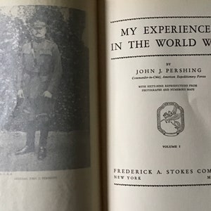 May include: A black and white photo of a man in a military uniform. The photo is from the book "My Experiences in the World War" by John J. Pershing, Commander-in-Chief, American Expeditionary Forces. The book was published in 1931 by Frederick A. Stokes Company.