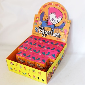 Op de afbeelding: Een displaydoos gevuld met roze en oranje dozen met cartoon illustraties. De displaydoos heeft een geel en oranje ontwerp met de tekst "The Heroes of Burgertown" en een cartoonfiguur. De dozen zijn in rijen gerangschikt.