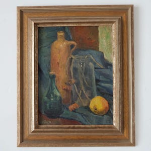 May include: A still life painting of a brown ceramic jug, a green glass bottle, a clear glass jar with twigs inside, and a yellow fruit on a blue cloth.