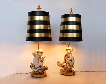 2 Hollywood Regency style 1980&#39;s ceramic monkey desk or table lamps. Two sitting monkeys and black/gold lamp shades
