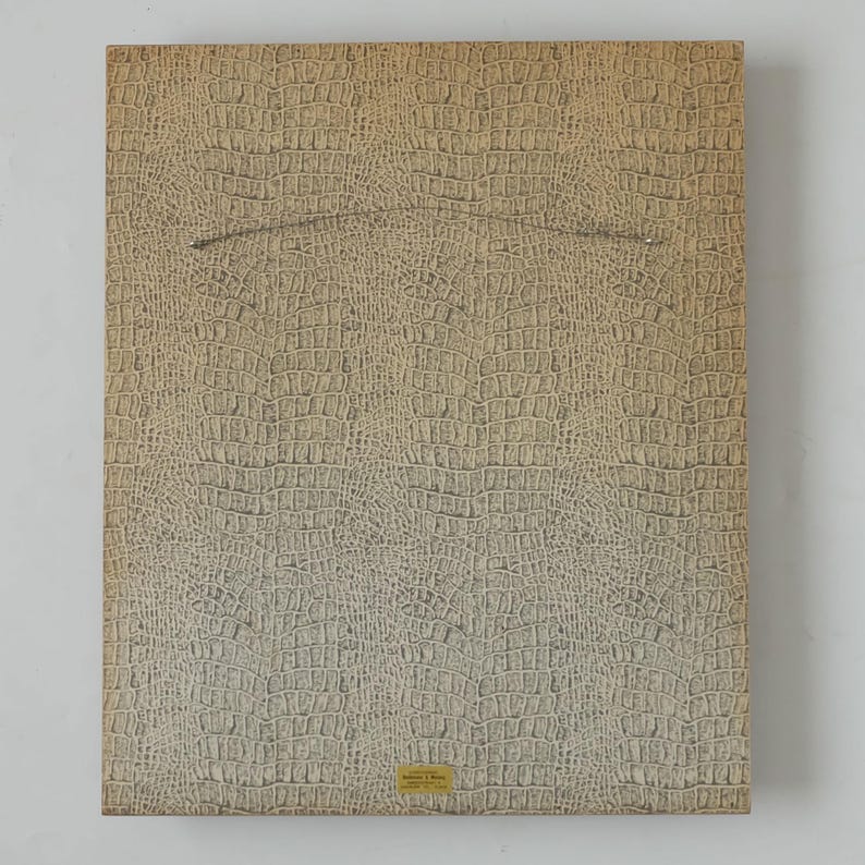 May include: A beige textured background with a crocodile skin pattern. A small white label with black text is in the bottom right corner.