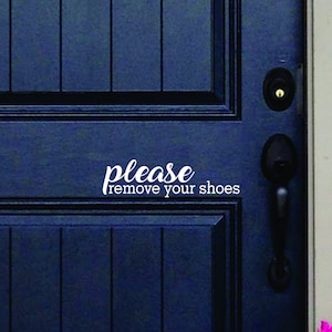 May include: A dark blue front door featuring a white vinyl decal with the text please remove your shoes in a combination of script and sans-serif fonts. The door includes a black handle and a deadbolt lock set against a paneled door surface.
