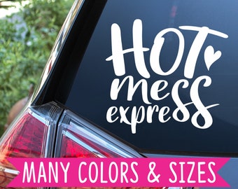 Op de afbeelding: Witte vinyl sticker met de tekst "Hot mess express" op een zwart autovenster. De tekst is in een cursief lettertype met een klein hartje na het woord "Hot". De sticker is verkrijgbaar in vele kleuren en maten.