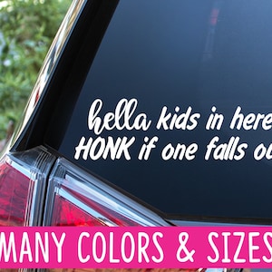 May include: A white vinyl car sticker with the text "hella kids in here! HONK if one falls out!" on a black car. The text is in a handwritten font. The sticker is available in many colours and sizes.