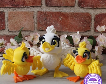 May include: Three decorative duck figurines. Two are yellow with orange feet and wings, and one is white. All have black-lined eyes and yellow beaks. The background features a brick wall and white flowers.