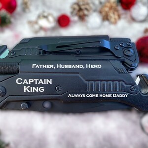 May include: Black multi-tool with a silver inscription that reads "Father, Husband, Hero, Captain King, Always Come Home Daddy".