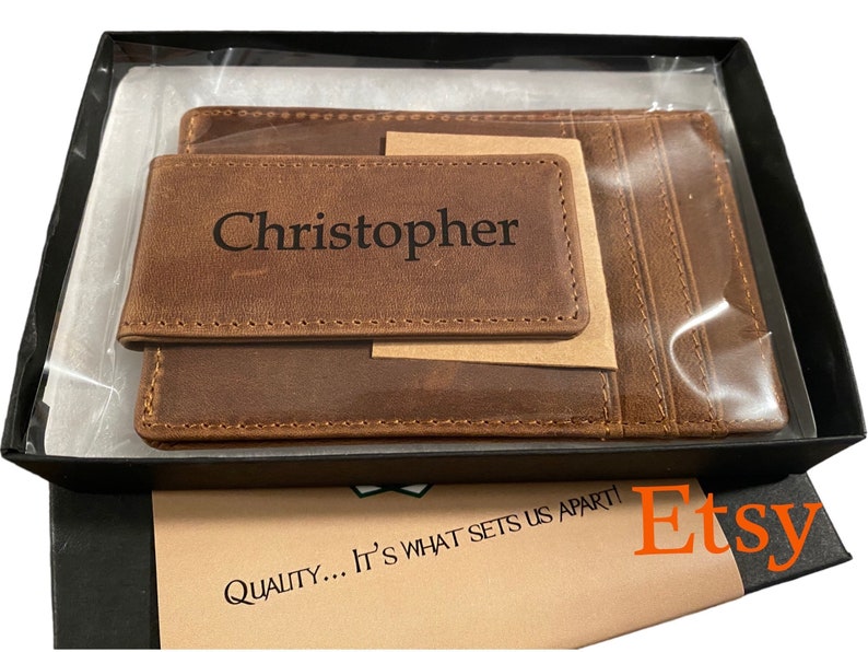 May include: A brown leather wallet with a money clip and a card slot. The wallet is personalized with the name "Christopher".