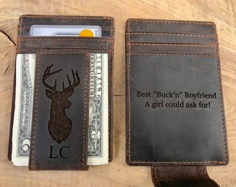 May include: Brown leather wallet with a money clip and a deer silhouette engraved on the front. The back of the wallet has the text "Best "Buck'n" Boyfriend A girl could ask for!" engraved on it.
