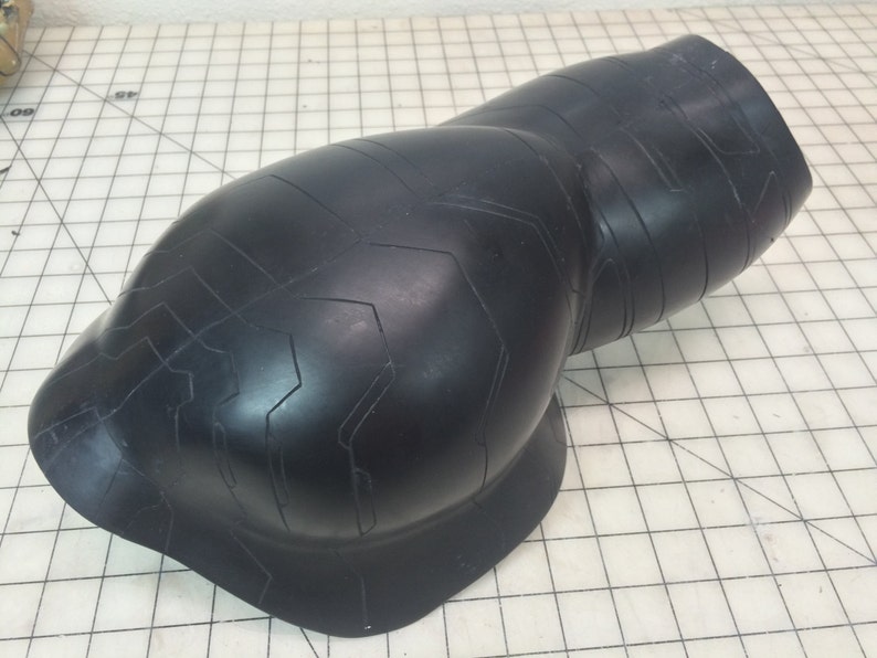 May include: Black rubber elbow pad with a textured surface and a geometric pattern.