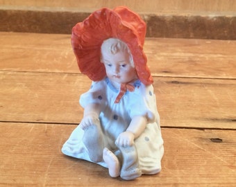 Early 1900s Gebruder Heubach Bonnet Girl Piano Baby Porcelain Figurine with Red Bonnet - In Excellent Condition - Antique