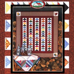 May include: A quilt pattern featuring a row of geese in various colors and patterns. The quilt is displayed against a backdrop of stacked firewood and a small table with a matching quilt. The title "Get All Your Geese In A Row" is displayed at the bottom of the image.