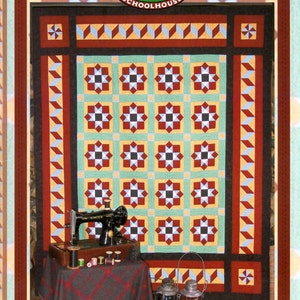 May include: A colorful quilt with a central pattern of star-like shapes in red, black, and white, set against a light green background. The quilt is framed by a dark border with geometric designs. A vintage sewing machine and accessories are displayed in front of the quilt. The text "ME & D'ARCY MCGEE" is visible.